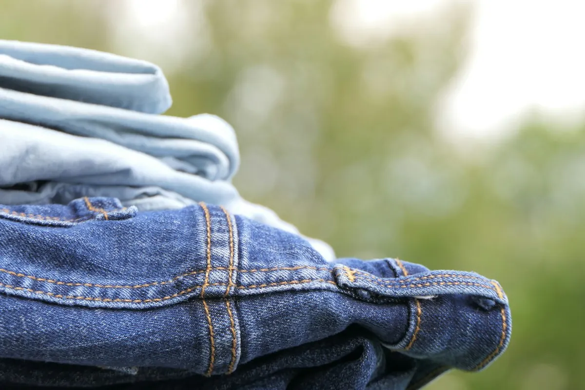 Jeans: folded denim jeans stacked in a shop — reference photo from our export range